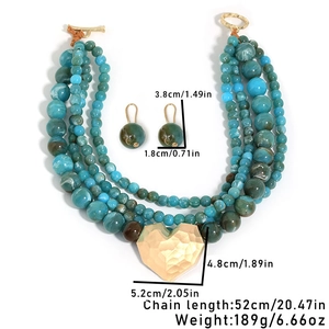 Detail of four-layer bohemian beaded necklace with large gold heart pendant and earrings