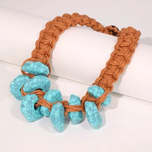 Handmade bohemian turquoise necklace with woven orange-brown cord on white display