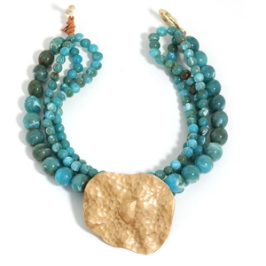 Bohemian layered beaded necklace with large hammered gold pendant on white background