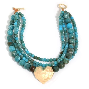 Detail of bohemian multilayered blue marble bead necklace with gold heart pendant