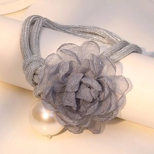 Macro shot of gray organza flower and large pearl detail on a woven silk necklace