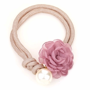 Detail of a handmade champagne cord hair tie with a chiffon flower and faux pearl