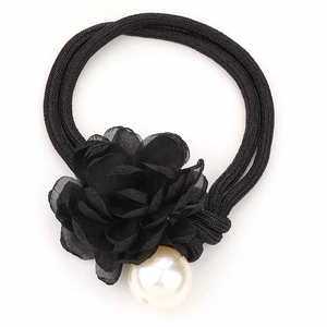 Detail view of a black chiffon flower hair tie featuring a large white pearl accent