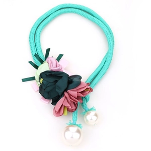 Detailed view of woven teal rope necklace with handmade fabric flowers and pearls