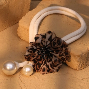 Retro fabric leopard print flower hair tie with pearls on stone background