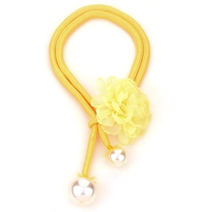Detail of yellow woven necklace with large white faux pearls and a soft chiffon flower