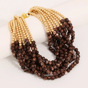 Detail of bohemian layered beaded necklace with marble-patterned and golden beads