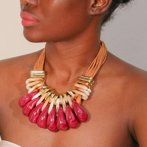 Detail of bohemian multilayer statement necklace with orange ropes and resin pendants