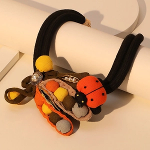 Handmade ladybug and pea pod hair tie with thick braided rope and colorful pom-poms