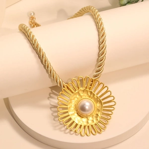 Minimalist golden rope chain necklace with a large pearl sunflower pendant on white stand
