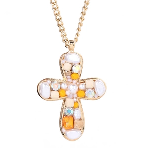 Golden cross necklace with imitation pearls, yellow beads, and rhinestones on white background