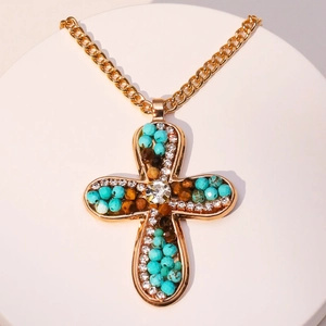 Cross pendant necklace with turquoise beads and crystals on a minimalist display stand