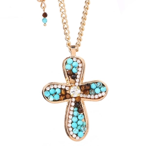 Golden cross necklace with blue crystal beads and sparkling rhinestones on white backdrop