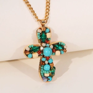 Collier artisanal croix en perles turquoise et bois sur une chaîne dorée fine