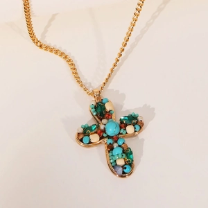 Collier croix dorée bohème avec perles colorées et turquoise en vue latérale à 45 degrés