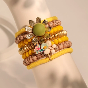 Multi-layer sunflower beaded bracelet set with yellow charms on a model wrist