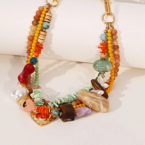 Collier bohème multicouche avec perles en pierre naturelle et pendentif cœur sur fond blanc