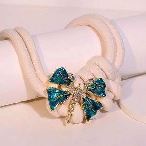 Golden dragonfly necklace with teal enamel wings and rhinestones on thick cord