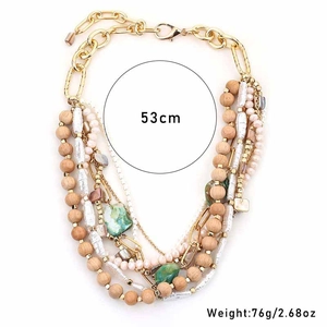 Detail of layered bohemian necklace with wooden beads, pearls, and green stone accents