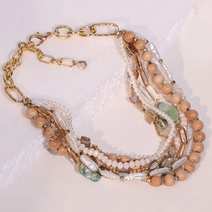 Bohemian multilayer necklace with wood beads, pearls, and stones on a textured surface
