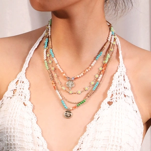 Detail of layered bohemian necklace with daisy charms and colorful handmade beads