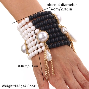 Macro detail of multi-layer black and white beaded bracelet with imitation pearl fringe