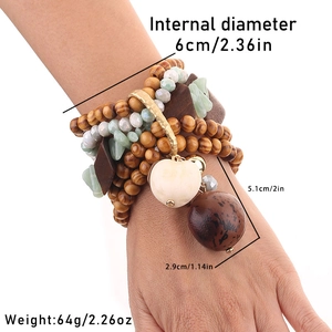 Détail du bracelet multicouche bohème en perles de bois avec pendentif cœur et pierres vertes