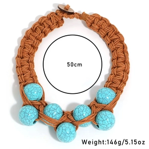 Close-up of handmade woven rope necklace with turquoise beads and wood button clasp