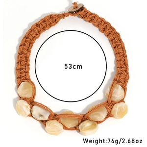 Detail of handmade braided rope necklace with yellow resin beads and wood button