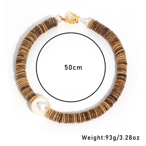 Détail du collier en noix de coco avec grande perle blanche et fermoir à bascule doré