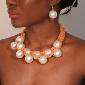 Handwoven orange rope necklace with oversized imitation pearls and matching earrings