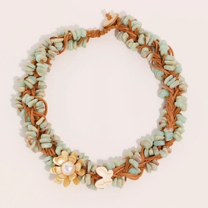Collar artesanal tejido con piedras naturales verdes y detalle de flor dorada decorativa