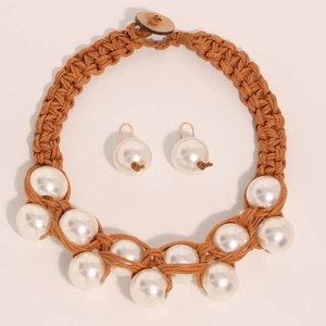 Close-up of handmade woven thick rope necklace with large faux pearls and matching earrings