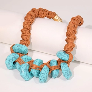 Handcrafted ethnic necklace featuring irregular turquoise beads and braided cord on a stand