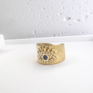 Détail d'une bague large en or 18 carats avec motif œil et zircon bleu incrusté