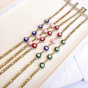 Gold Figaro bracelets featuring colorful enamel evil eye charms in multiple shades