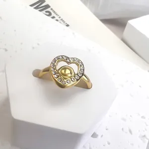 Bague cœur évidé en or avec accents de zircone blanche sur présentoir minimaliste