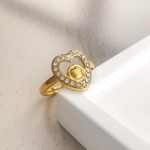 Bague cœur évidée dorée minimaliste avec cristaux scintillants sur socle blanc