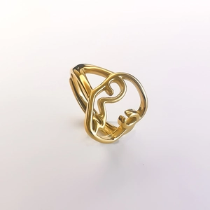 Detailed close-up of golden abstract face silhouette ring with polished metallic finish