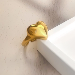 Detail shot of a chunky 3D heart-shaped ring in polished 18K gold stainless steel