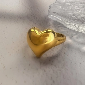 Macro shot of polished 18K gold heart ring featuring a 3D chunky minimalist design