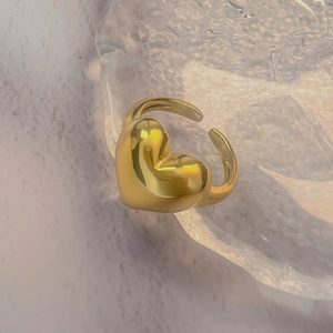 Macro detail of 18K gold-plated chunky heart ring on crystal stone with warm lighting