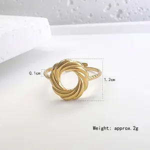 French style gold twisted steel ring on white textured stone background for women