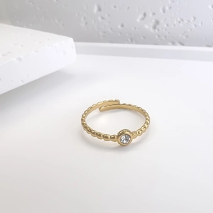 Detail of gold beaded open ring featuring a single sparkling center cubic zirconia