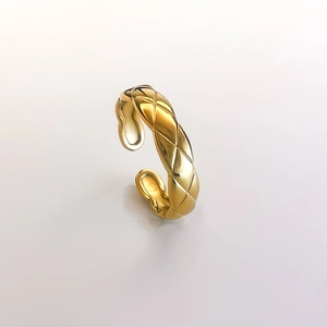 Close-up of golden quilted pattern ring with polished finish and adjustable open design