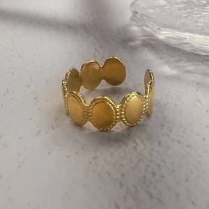 Minimalist gold-plated open ring featuring a unique oval disk chain design on marble surface
