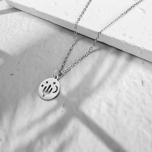Gros plan détaillé du pendentif cactus et étoile en argent sur une surface texturée