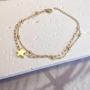 Detailed view of double-layer gold stainless steel bracelet with star pendant and beads
