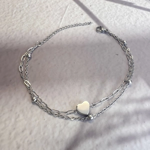 Close-up of dual-layer stainless steel heart bracelet with paperclip chain in silver