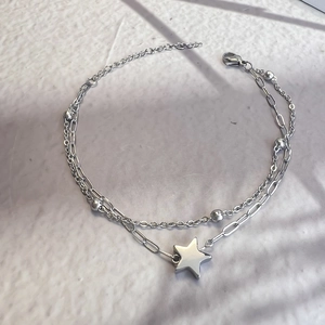 Detail of silver double-layered star bracelet with paperclip chain and lobster clasp
